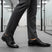 bugatti Morino I black leather derby shoes, paired with grey dress pants, in an office hallway.
