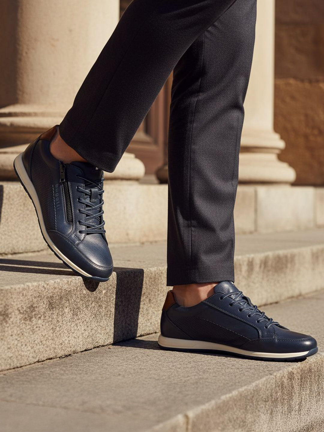 Lifestyle view of bugatti Thorello dark blue premium leather sneakers with side zip, paired with dark dress pants.
