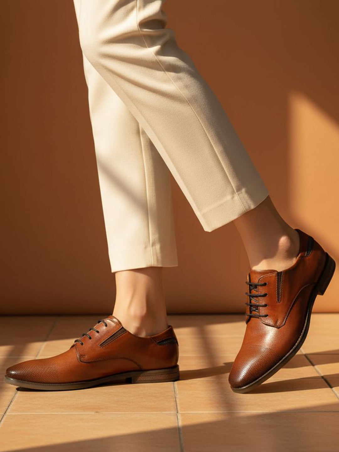 bugatti Menello cognac leather derby shoes with black laces, paired with beige pants.
