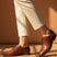 bugatti Menello cognac leather derby shoes with black laces, paired with beige pants.