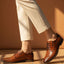 bugatti Menello cognac leather derby shoes with black laces, paired with beige pants.