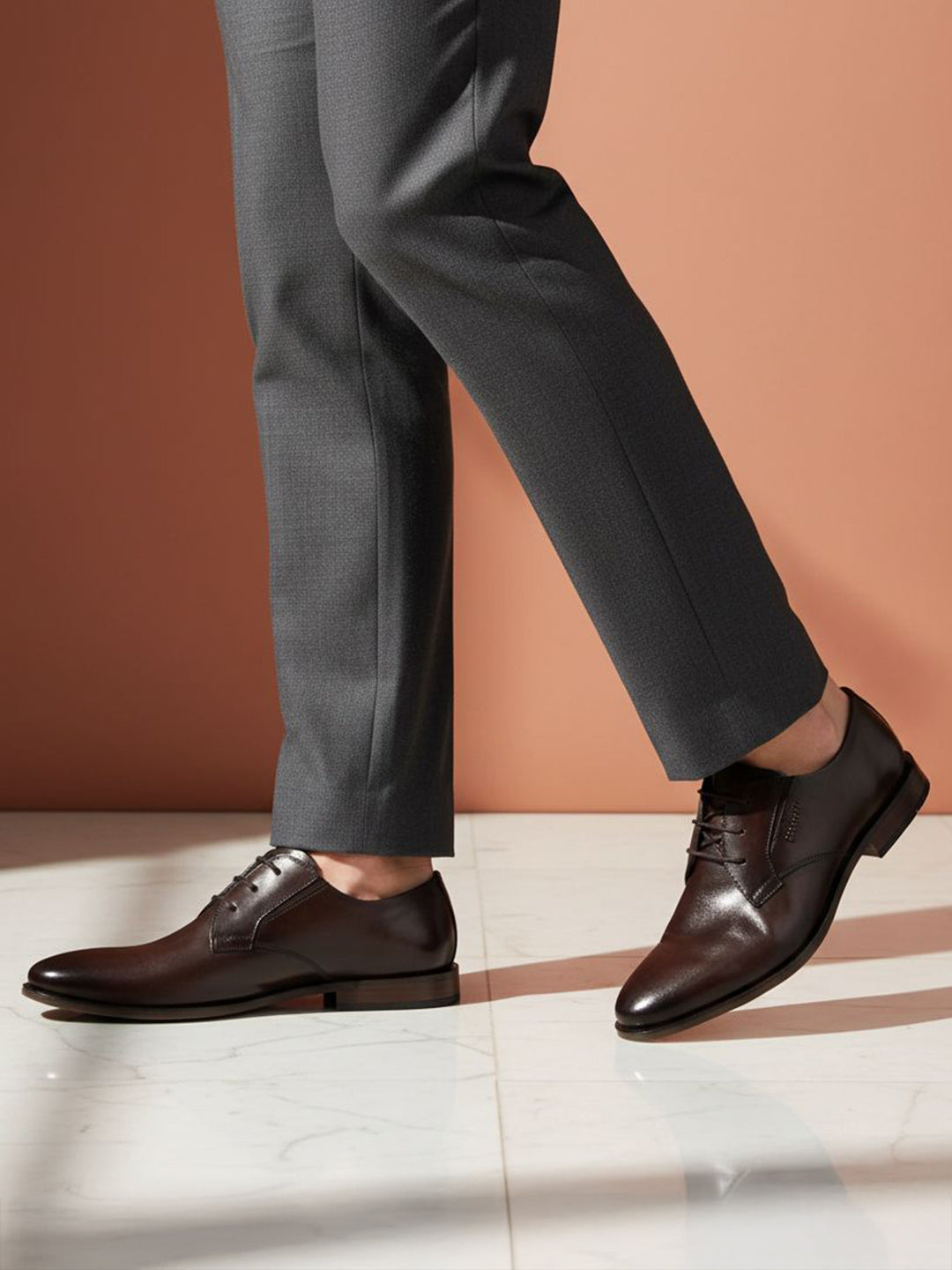 bugatti Gapo dark brown premium leather derby shoes with laces, paired with gray dress pants.
