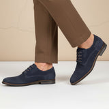 Lifestyle image of bugatti Sula dark blue leather derby shoes with brown laces, worn with brown trousers.