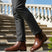 bugatti Amros Cognac Premium Leather Comfort Chelsea Boots with side zipper, worn with grey slacks on stairs.
