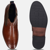 Cognac-colored bugatti leather Chelsea boot with side zipper and contrasting sole, shown in a top-down studio shot.
