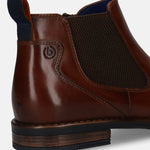 Cropped side view of a brown leather bugatti Chelsea boot featuring elastic side panels and a dark blue pull tab.
