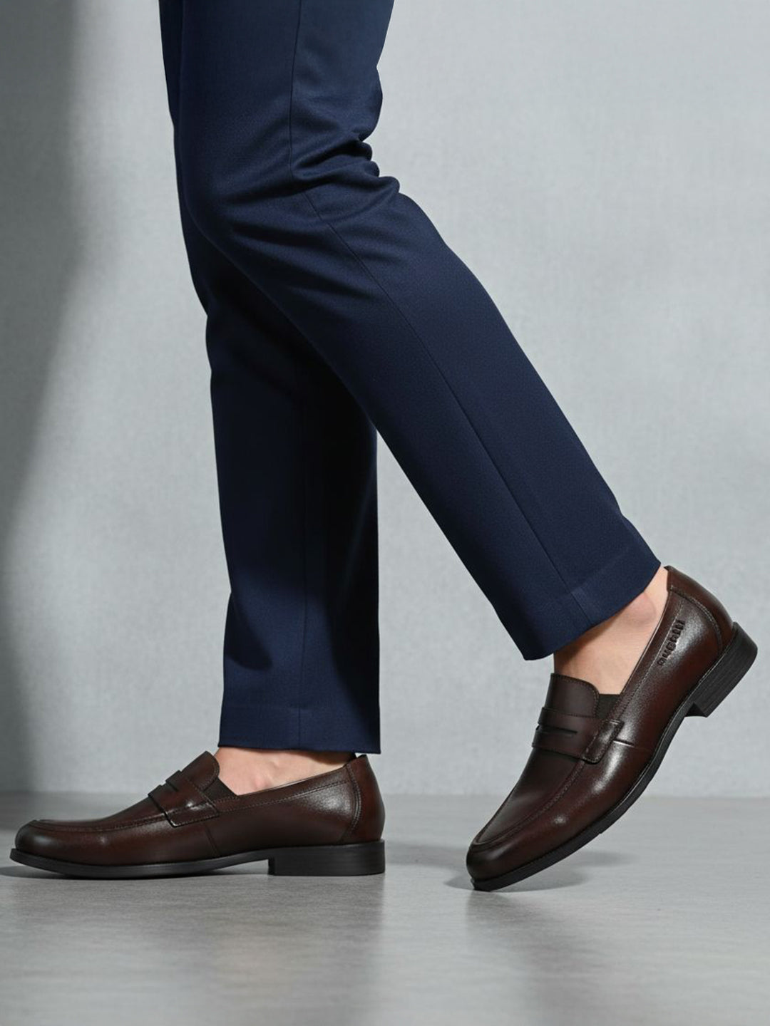 bugatti Theobaldo dark brown premium leather penny loafers, complemented by navy dress pants.

