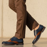 bugatti Caleo Exko dark blue leather formal shoe with brown accents, paired with brown trousers in a lifestyle shot.
