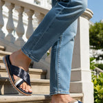 bugatti Limon dark blue leather sandals with cross straps, worn with jeans on stairs.
