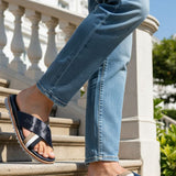 bugatti Limon dark blue leather sandals with cross straps, worn with jeans on stairs.
