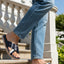 bugatti Limon dark blue leather sandals with cross straps, worn with jeans on stairs.
