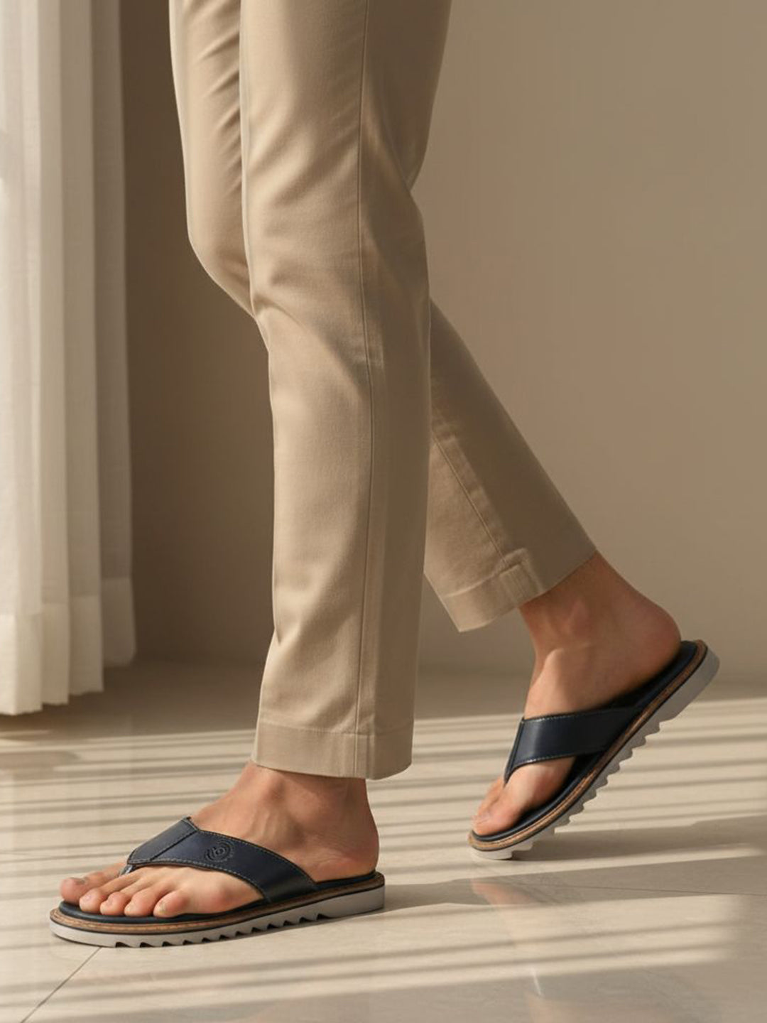 Lifestyle view of bugatti Limon sandals in dark blue premium leather, a comfortable thong style.
