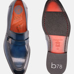 Blue leather penny loafers by Bugatti, shown with orange insole and brand name embossed on the sole.