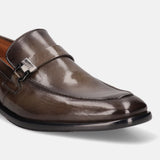 Dark green leather penny loafer by bugatti with a silver-tone decorative buckle.