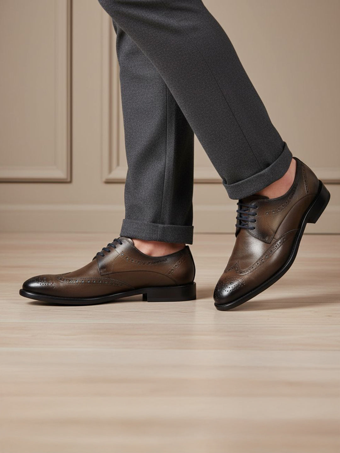 bugatti Livorno Flex Evo dark grey leather formal shoes, with brogue detailing, styled with grey trousers.
