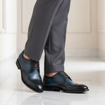 bugatti Livorno Flex Evo dark blue leather derby shoes with black accents, styled with gray dress pants.
