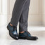 bugatti Livorno Flex Evo dark blue leather derby shoes with black accents, styled with gray dress pants.
