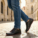 Person wearing black Men's bugatti Sneakers featuring a round plain toe, zero heels heel. Made from premium genuine leather with a durable tr outsole.