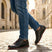 Person wearing black Men's bugatti Sneakers featuring a round plain toe, zero heels heel. Made from premium genuine leather with a durable tr outsole.
