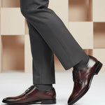 Lifestyle shot of bugatti Rico Flex bordo dress shoes, paired with grey dress pants and grey socks.