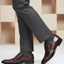 Lifestyle shot of bugatti Rico Flex bordo dress shoes, paired with grey dress pants and grey socks.