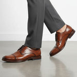 Lifestyle shot of bugatti Mansueto Flex Cognac leather derby formal shoes with black laces and blue sole accent.
