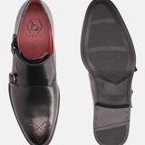 Black premium leather monk strap shoe by Bugatti, featuring red accents, perforated details, and a textured sole.