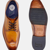 Yellow leather derby formal shoe by bugatti with decorative perforations, shown with a dark outsole.