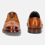 Yellow premium leather oxford formal shoes by bugatti, featuring black laces and decorative perforations.