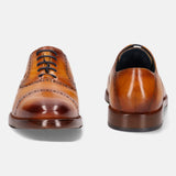 Yellow premium leather oxford formal shoes by bugatti, featuring black laces and decorative perforations.