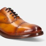 Yellow leather oxford formal shoe by Bugatti with brogue detailing and dark laces.