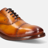 Yellow leather oxford formal shoe by Bugatti with brogue detailing and dark laces.