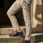 bugatti Caleo Exko dark blue leather derby shoes, accented with a brown stripe and paired with khaki trousers.
