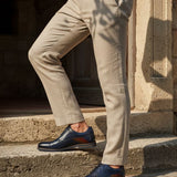 bugatti Caleo Exko dark blue leather derby shoes, accented with a brown stripe and paired with khaki trousers.
