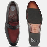 Black leather penny loafers by bugatti with a contrasting burgundy vamp, showing the insole and sole.