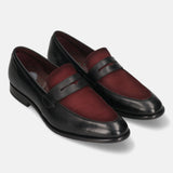 Black leather penny loafers by bugatti, featuring a burgundy suede vamp and subtle stitching details.