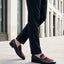 Lifestyle image of bugatti Rico black leather penny loafers with a burgundy suede accent.
