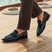 bugatti Rico black premium leather comfort penny loafers with blue accent on a boat deck.