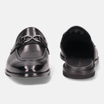 Black leather slip-on shoe by bugatti with a metallic decorative element on a white background.