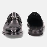 Black leather slip-on shoe by bugatti with a metallic decorative element on a white background.