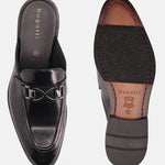 Black leather slip-on formal shoes by bugatti with a metal accent and a leather sole.