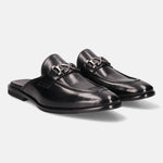 Black leather slip-on shoes by bugatti with silver-toned embellishments, displayed on a white backdrop.