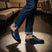 bugatti Rico Blue leather slip-on shoe with buckle detail, paired with blue denim jeans in a lifestyle shot.