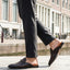 Lifestyle shot of bugatti Rico Brown premium leather slip-on shoe, featuring a woven texture and a metal horse-bit detail.
