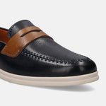 Dark blue leather slip-on shoe by Bugatti, featuring a brown strap and decorative stitching.