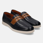 Blue leather slip-on shoes by bugatti, featuring a brown leather strap and white soles.