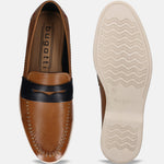 Cognac leather slip-on shoe by bugatti with a black strap, visible stitching, and ridged outsole.