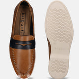Cognac leather slip-on shoe by bugatti with a black strap, visible stitching, and ridged outsole.