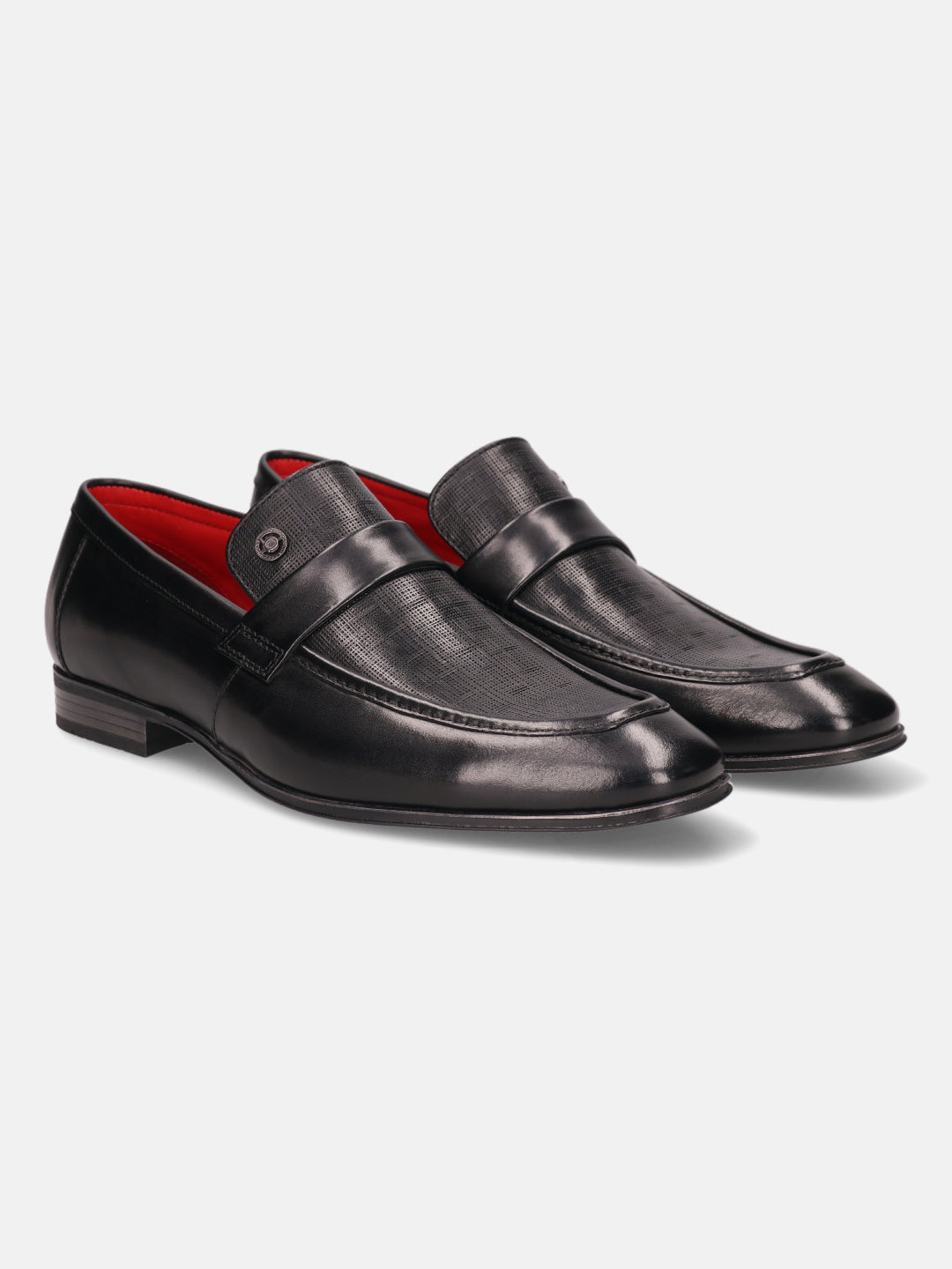 Black leather penny loafers by Bugatti, featuring a subtle perforated texture and red lining.