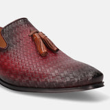 Red leather slip-on shoe by bugatti, with woven texture and decorative tassels.